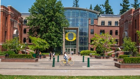 Looking towards a glass-front building, a yellow "O" logo over the doorway