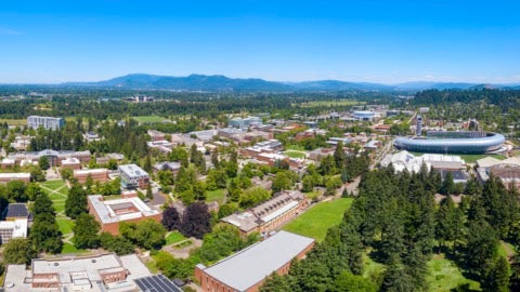 Airborne view of the UO campus, mountains in the background.