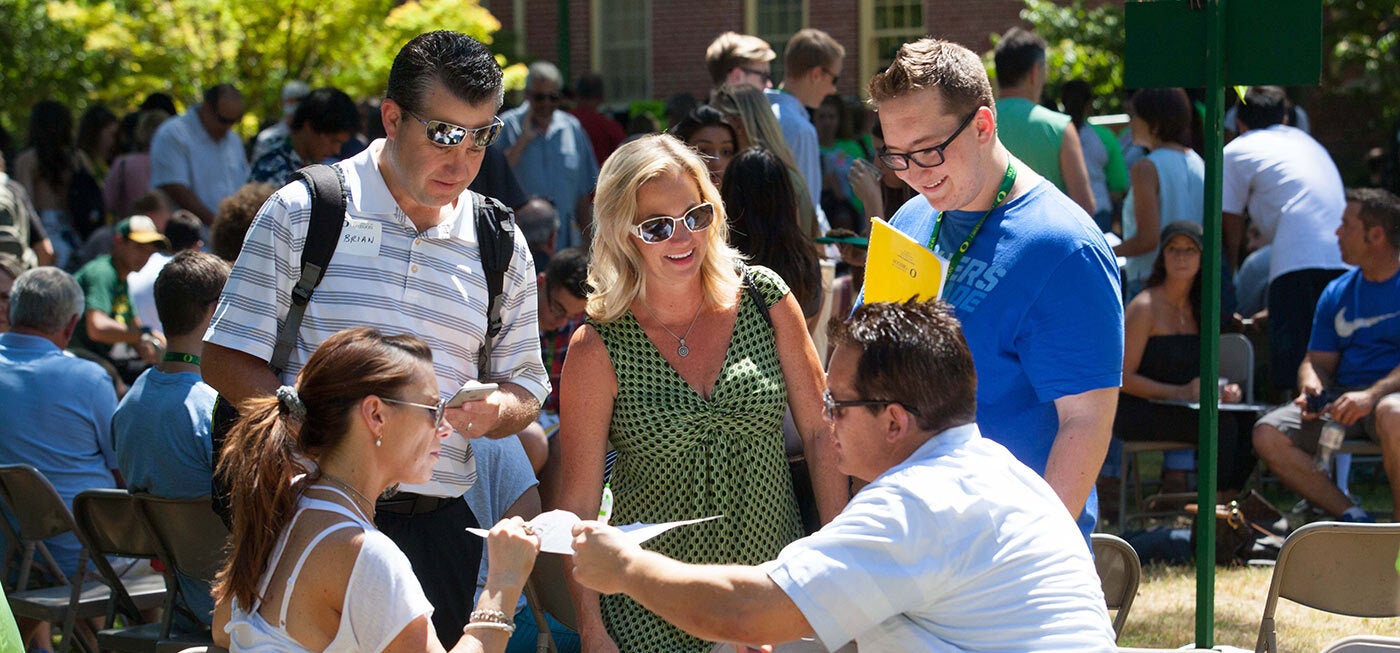 People talking with each other with other conference attendees in the background